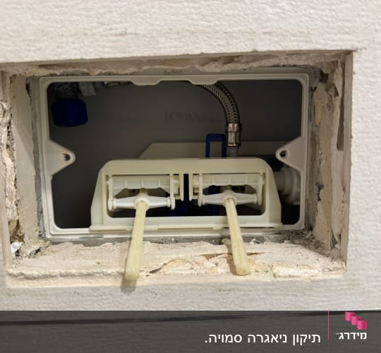 תמונה של מערכת אינסטלציה בקיר עם צינורות וחיבורים